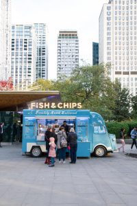 people beside Fish & Chips food truck at the city during day